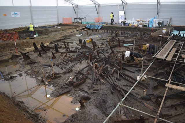 Working shot showing the Central Eastern Area. The large, dark timbers to the left of the image are posts from the causeway. In the centre of the image, to the left of the white sample buckets, you can just make out the interior post ring from RH 2.